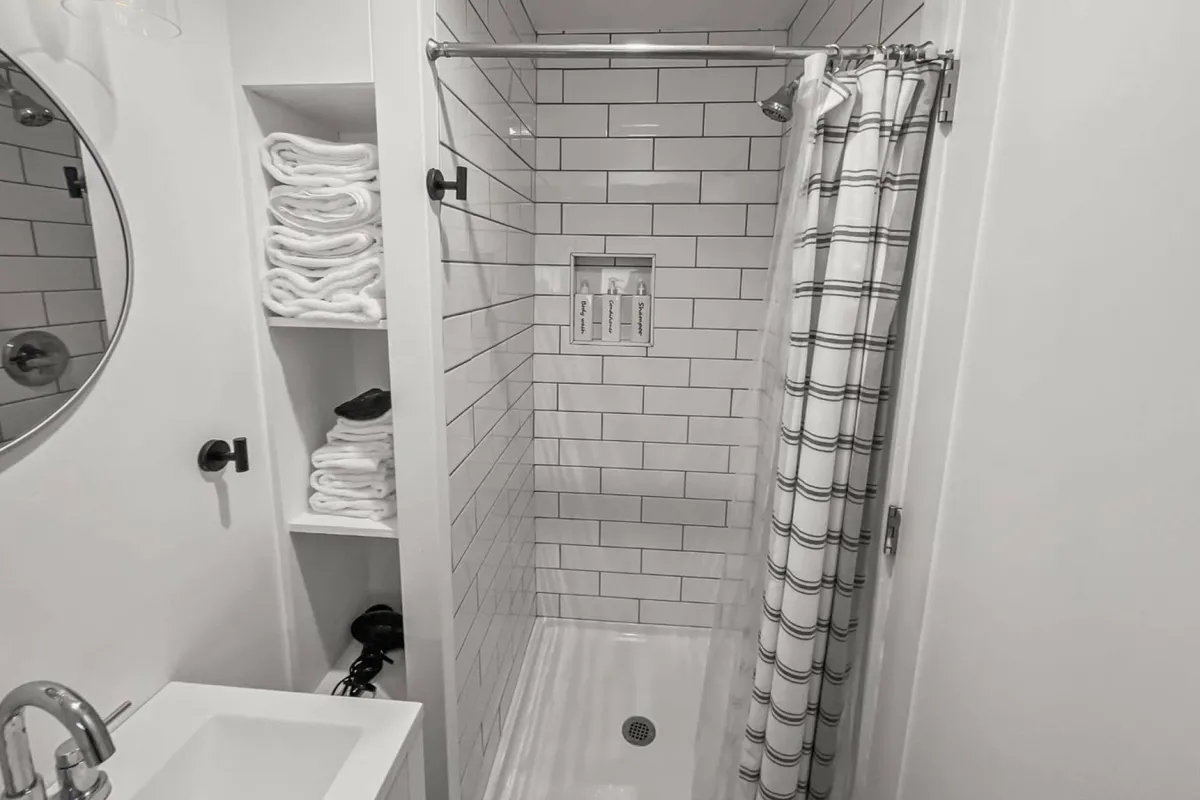 An inviting shower area complete with a sleek mirror, organized towel storage, and a spa-inspired ambiance. The space feels relaxing, practical, and designed for easy self-care after beach adventures.